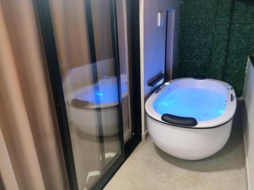 a bathroom with a tub and a toilet and a shower at Loft completo com HIDRO e piscina próx à praia in Caraguatatuba