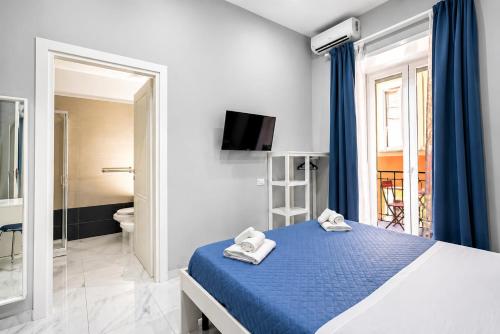 a bedroom with a blue bed and a bathroom at Neve Al Sole Modern Suites near Metro Materdei in Naples Center in Naples