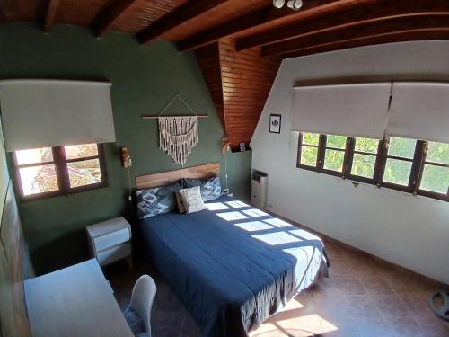 a bedroom with a blue bed in a room with windows at Casa Verde 3 in Godoy Cruz