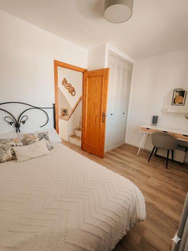 a bedroom with a bed and a desk in it at Costamar bungalow familiar, piscina y terraza, a 5 min de la playa in Arenales del Sol