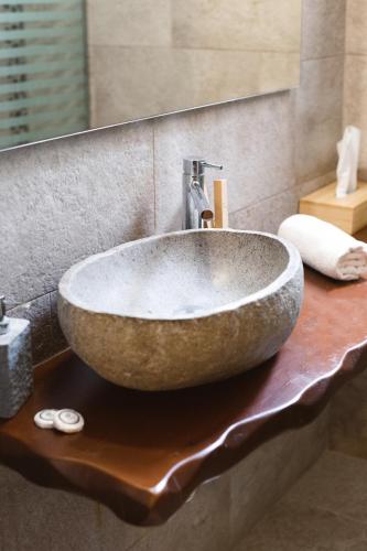 a stone sink on a counter in a bathroom at Amaryllis Suites Santorini in Fira