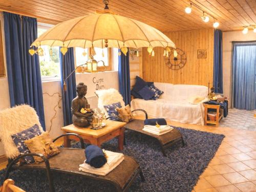 a living room with a bed and an umbrella at Gästehaus Schönfeld in Reit im Winkl