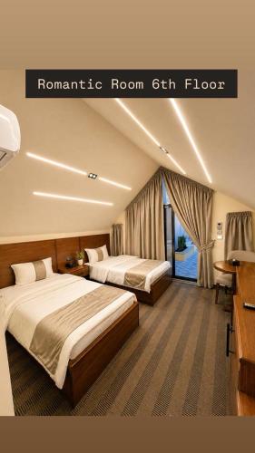 a hotel room with two beds and a window at North paradise hotel in Irbid
