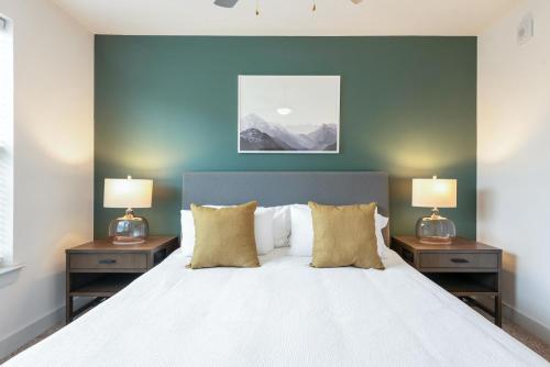a bedroom with a large white bed with two night stands at Landing Apartments - Reserve at City Place in Conroe
