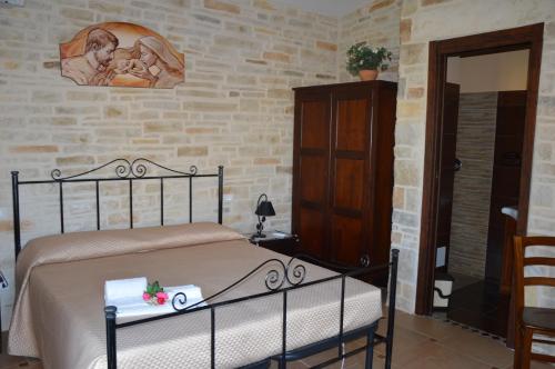 a bedroom with a bed and a brick wall at Il Quadrifoglio in Trapani