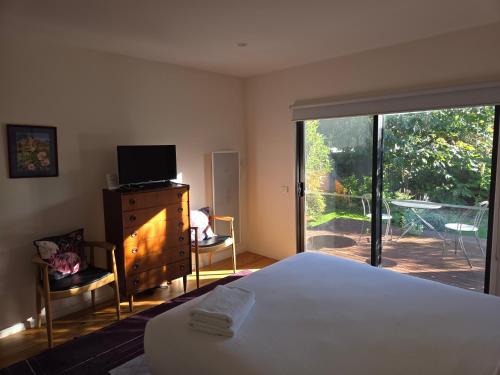 a bedroom with a bed and a sliding glass door at SeymourViews Apollo Bay in Apollo Bay