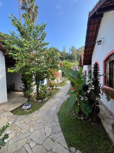 a stone walkway with a tree next to a building at Pousada Laço e Nó in Itatiaia