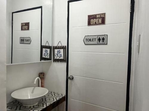 a bathroom with a white door and a sink at Anabelle Residence in Dumaguete