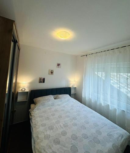 a bedroom with a bed and a window at Apartment Zlatko in Matulji