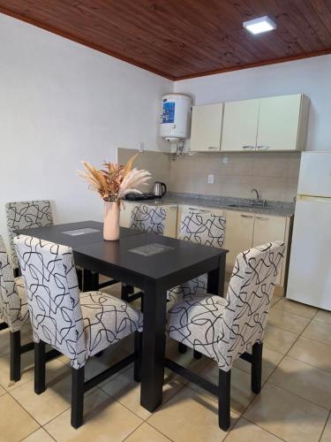 a kitchen with a black table and some chairs at Rincón Esmeralda in Mercedes