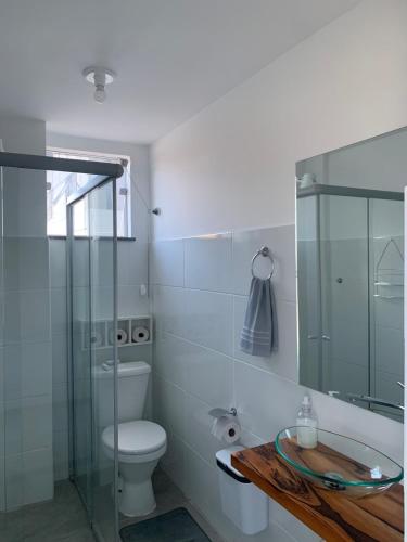 a bathroom with a toilet and a glass shower at Studio moderno com cozinha completa e Wi-Fi centro in Barbacena