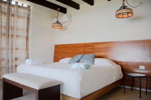 a bedroom with a large white bed and two lights at Casa Sacre in Cuatunalco