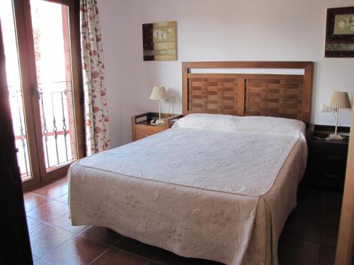 um quarto com uma cama grande e 2 janelas em Hotel-Apartamento Carolina y Vanessa em San José