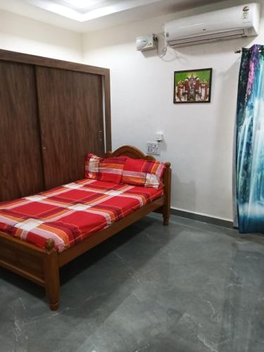 a bed in a room with a red and white blanket at Mahadev grand in Tirupati