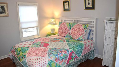 a bedroom with a bed with a colorful quilt at Sunset Shore House Second Floor in West Cape May