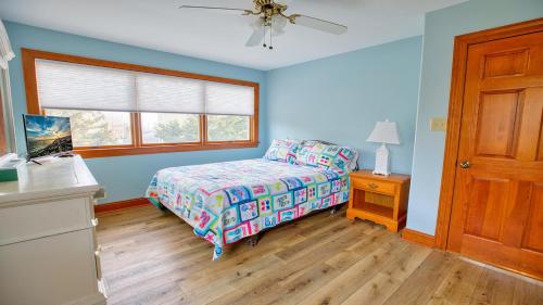 a blue bedroom with a bed and a window at Sunset Sands And Sea Dogs in West Cape May
