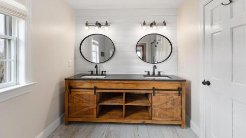 a bathroom with two sinks and two mirrors at Sunset Sands And Sea Dogs in West Cape May