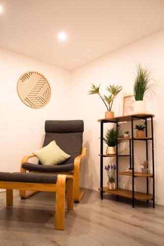a living room with a chair and a shelf with plants at Modernes Haus nahe See mit Garten & Terrasse in Velm