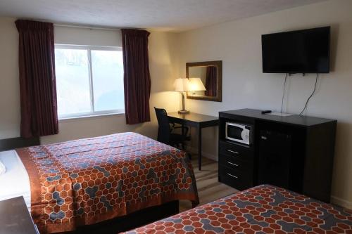 a hotel room with two beds and a desk with a television at FairBridge Inn Express Chesterton in Chesterton