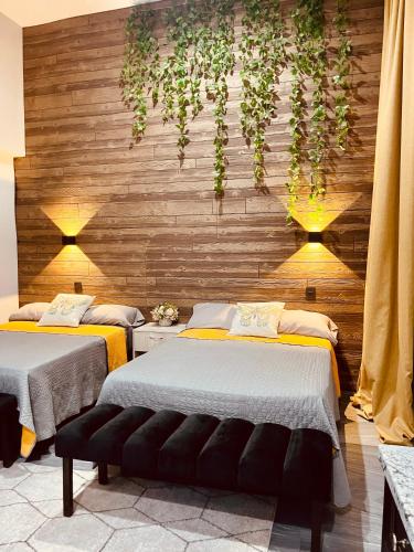 two beds in a room with plants on the wall at Casa Luque in Culiacán