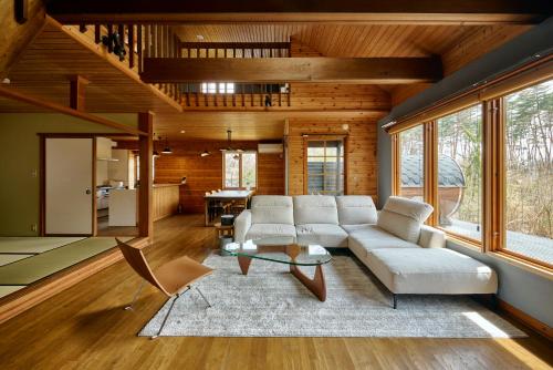 a living room with a couch and a table at Ember Resort AZUMIMO 静寂の森に佇むプライベートサウナ付き一棟貸しリトリート in Azumino