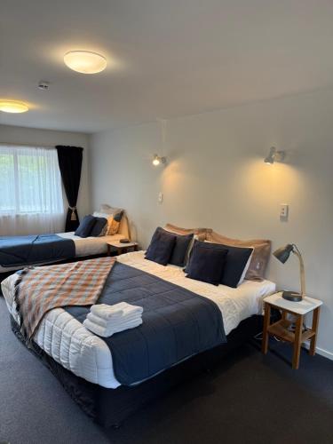 a hotel room with two beds and a lamp at #5 Glenorchy Alpine Suite in Glenorchy