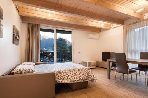 a bedroom with a bed and a desk and a window at Lake Home Holiday in Como