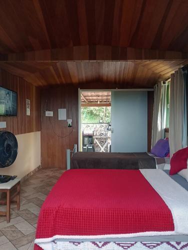 a bedroom with a large bed with a red blanket at Alta Vista in Penedo
