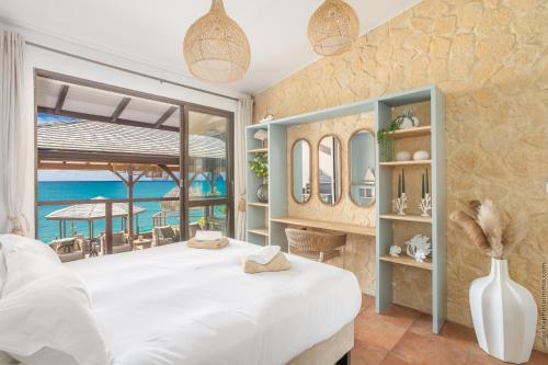 a bedroom with a bed with a view of the ocean at La Sirene du Diamant, villa de luxe sur la plage,18 personnes in Le Diamant