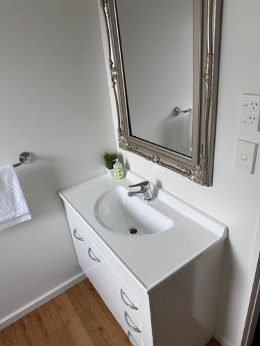a bathroom with a white sink and a mirror at #5 Glenorchy Alpine Suite in Glenorchy