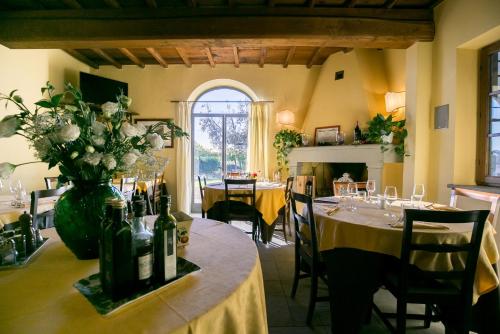 a restaurant with tables with bottles and flowers on them at Le Fonti A San Giorgio in Montespertoli