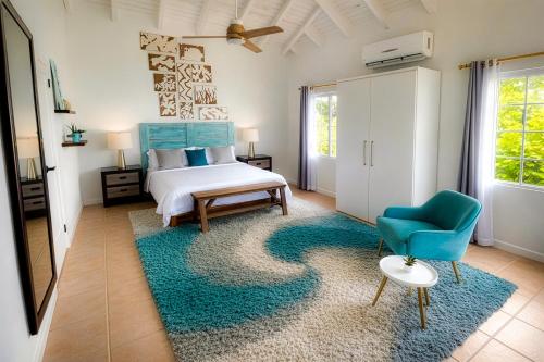a bedroom with a bed and a blue chair at Clearview Villas Upper in Island Harbour