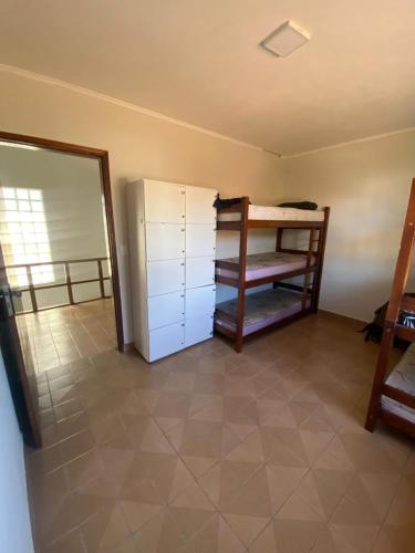 a room with a refrigerator and a room with a window at Sool Beach Hostel in Bertioga