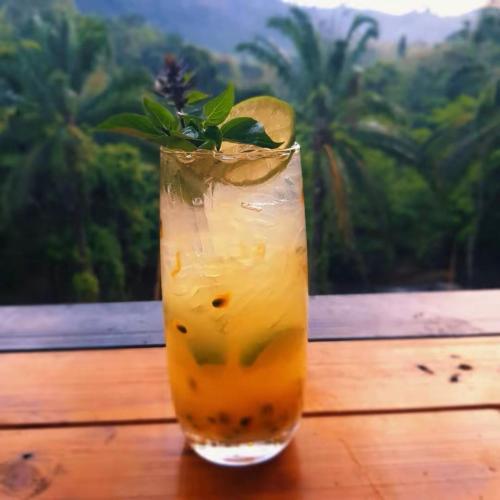 a drink sitting on a table with a lemon slice at KhaoSok Malin Glamping in Ban Bang Thong