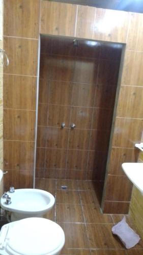 a bathroom with a shower with a toilet and a sink at Cabañas del Valle in Huerta Grande