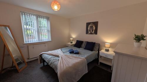 a bedroom with a bed and a table and a window at Large Modern House With Private Parking in Heeley