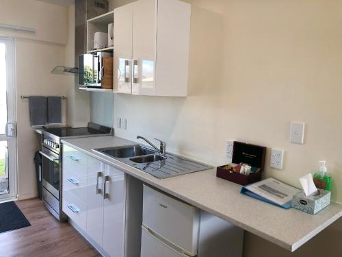 a kitchen with a sink and a counter top at Twin Coast Adventures Motel & Cycle Hire in Kaikohe