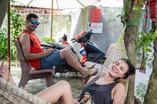 a man and a woman sitting in a hammock at Quynh Long Villa in Hoi An