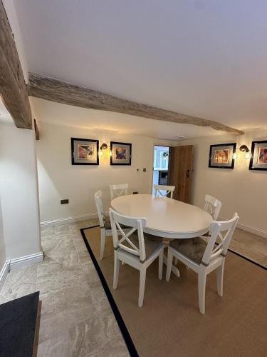a dining room with a white table and chairs at No2 Back Lane in Thrussington