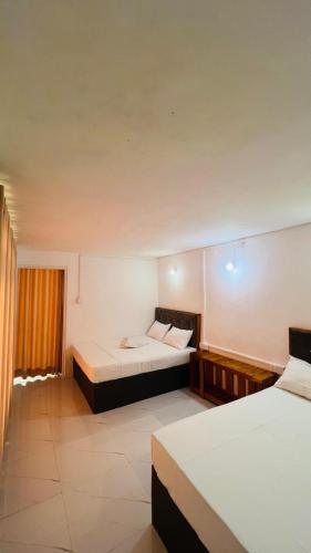 a room with two beds and a window at The victoria hill Cottage in Digana