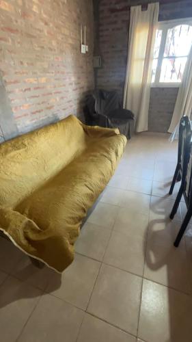 a bed with a yellow blanket on the floor in a room at Los Girasoles in Albardón