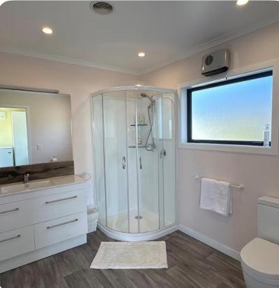 a large bathroom with a shower and a window at Bluff View in Ocean Beach