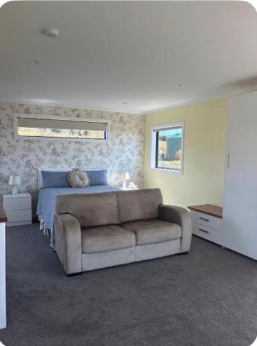 a bedroom with a bed and a couch and a television at Bluff View in Ocean Beach