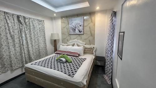 a bedroom with a bed with a teddy bear on it at Anabelle Residence in Dumaguete