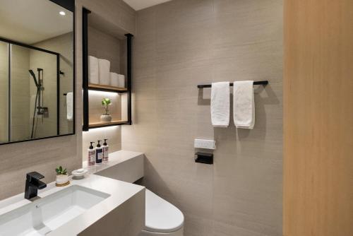 a bathroom with a white sink and a mirror at Somerset Palace Seoul in Seoul