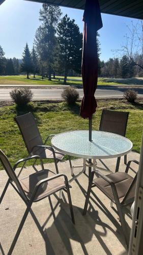 a glass table with chairs and an umbrella on a patio at Davis Beach Getaway Pet Friendly & Beach Access in McCall