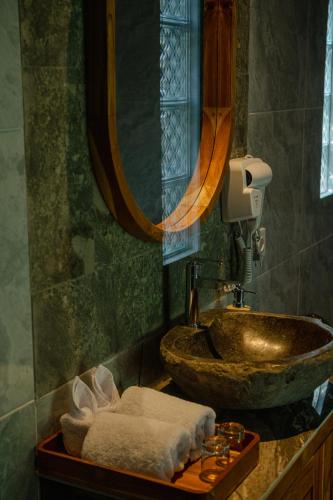 a bathroom with a sink and a mirror at Wanasari Villa in Tampaksiring