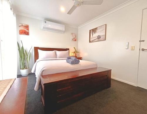 a bedroom with a bed with a wooden dresser at Deluxe Queen Room - Shared Bathroom in Holmview
