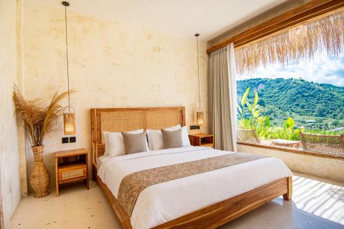 a bedroom with a bed and a large window at Sereno Lombok Resort in Selong Belanak
