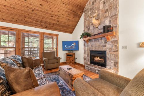a living room with a stone fireplace at SBL14 -Mayberry Lodge in Branson West
